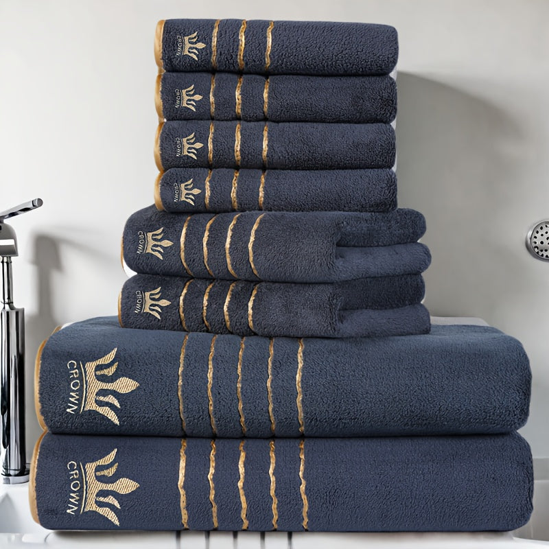 Stack of navy blue towels with gold accents on a bathroom counter.